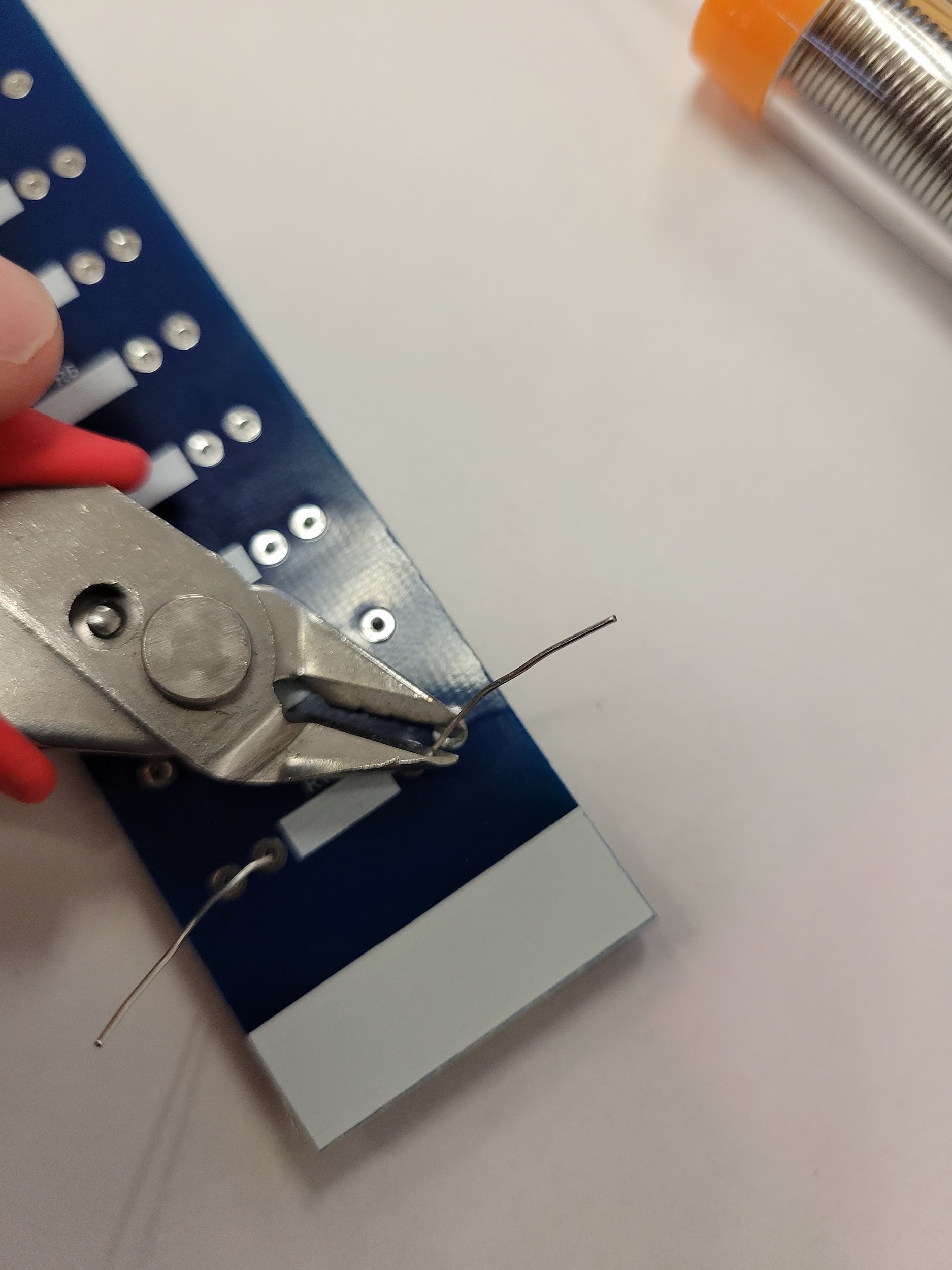 Flush cutters trimming resistor leads on the back of the board