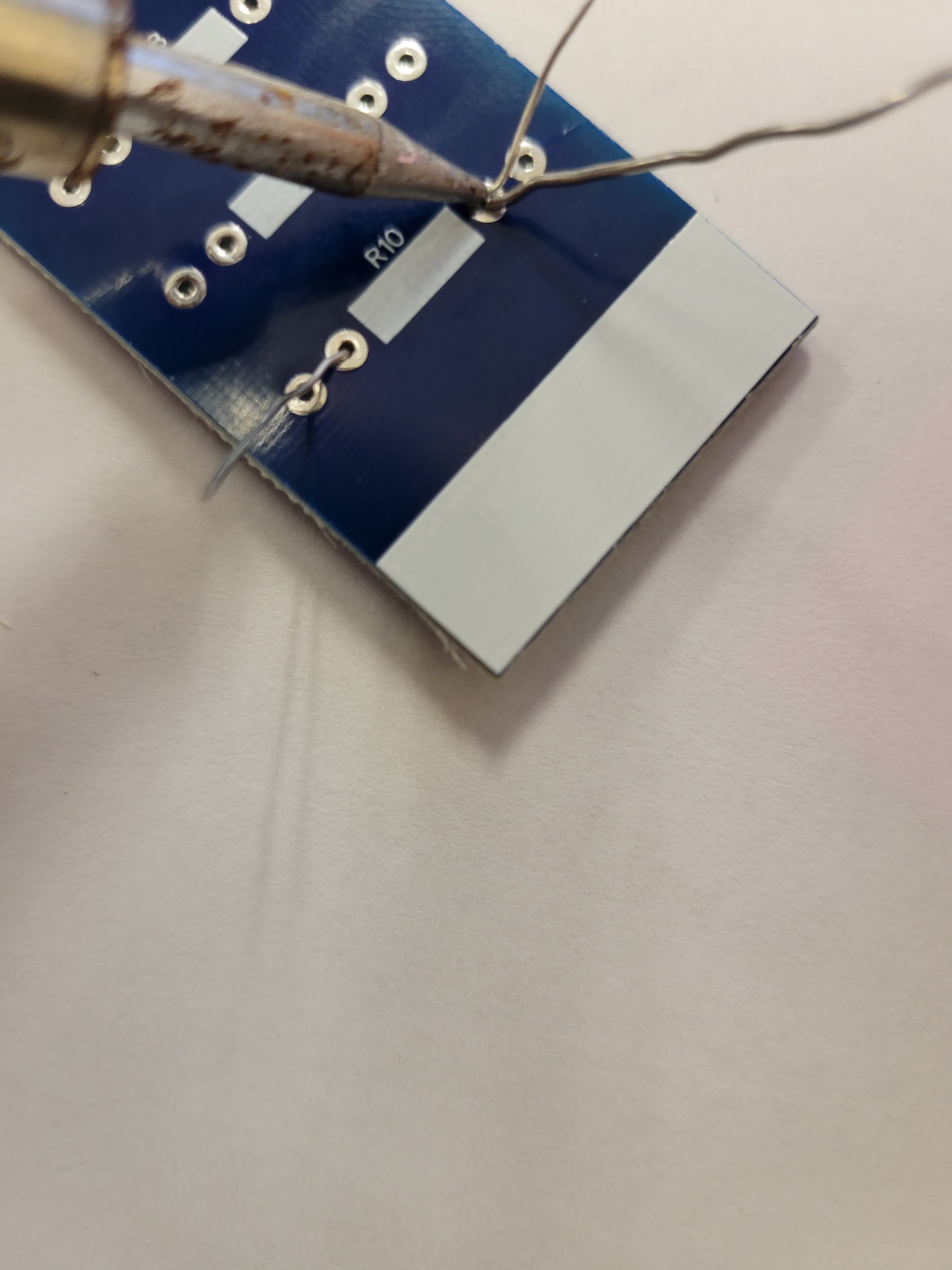 Soldering iron tip touching leads on the PCB